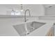 Close-up of a stainless steel kitchen sink with modern faucet and white countertops at 19777 N 76Th St # 3246, Scottsdale, AZ 85255