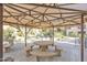 Outdoor seating area under a canopy, featuring a large round table with stone benches at 19777 N 76Th St # 3246, Scottsdale, AZ 85255