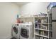 Well-organized laundry room with washer, dryer, and storage shelves at 20121 W Lilac St, Buckeye, AZ 85326