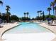 Sparkling community pool with lounge chairs and palm trees at 3301 S Goldfield Rd # 2068, Apache Junction, AZ 85119