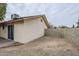 View of back of house with sliding glass doors, xeriscaping, and privacy wall at 4453 W Keating Cir, Glendale, AZ 85308