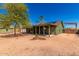 Exterior view of home showcasing the large backyard featuring a covered patio, desert landscaping and mature trees at 548 N 82Nd St, Mesa, AZ 85207