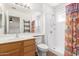 Well-lit bathroom with shower, decorative curtain, and spacious mirror over the vanity at 548 N 82Nd St, Mesa, AZ 85207