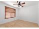 This bedroom features bamboo flooring, a ceiling fan, and a large window with wooden blinds at 548 N 82Nd St, Mesa, AZ 85207