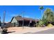 Single story house with attached carport, desert landscaping, and an American flag at 548 N 82Nd St, Mesa, AZ 85207