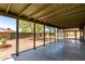 Covered patio with concrete flooring overlooks a large backyard featuring block fence, mature trees and desert landscaping at 548 N 82Nd St, Mesa, AZ 85207