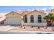 Tan house with tile roof, two-car garage, and landscaped front yard at 6877 S Oakmont Dr, Chandler, AZ 85249