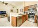 Open kitchen with breakfast bar, stainless steel appliances, and views to living room at 6877 S Oakmont Dr, Chandler, AZ 85249