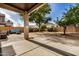 Covered patio, grassy area, and mature trees in the backyard at 6962 W Glenn Dr, Glendale, AZ 85303