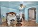 Light blue bedroom with wood flooring, a king-size bed and ceiling fan at 6962 W Glenn Dr, Glendale, AZ 85303
