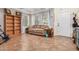 Living room with tiled floors, a sofa, and wooden shelves at 6962 W Glenn Dr, Glendale, AZ 85303