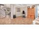 Living room with tiled floors, a bookcase, and a view to the staircase at 6962 W Glenn Dr, Glendale, AZ 85303