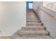 Indoor staircase with carpeted steps and wood railing at 6962 W Glenn Dr, Glendale, AZ 85303