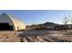 Exterior view of a property featuring a barn and a small house at 735 S Ruby Rd, Maricopa, AZ 85139