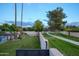 View of a backyard with green grass, tall trees, and a walkway at 8709 E Irish Hunter Trl, Scottsdale, AZ 85258