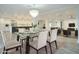 Bright, open-concept dining area featuring a modern glass table and stylish chandelier, seamlessly connected to the kitchen and living room at 8709 E Irish Hunter Trl, Scottsdale, AZ 85258