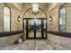 Double door entry with stone facade and large chandelier at 8802 E Rimrock Dr, Scottsdale, AZ 85255