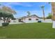 Large backyard with artificial grass, mature trees, privacy fence, and covered patio at 947 N 85Th Pl, Scottsdale, AZ 85257