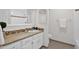 Bathroom with granite countertop, white cabinets, and tiled shower at 947 N 85Th Pl, Scottsdale, AZ 85257