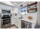 White kitchen with subway tile backsplash and stainless steel appliances at 10405 W Patrick Ln, Peoria, AZ 85383