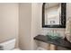 Elegant powder room with a glass vessel sink and mosaic mirror at 12544 N 120Th Pl, Scottsdale, AZ 85259