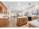 Modern kitchen with light wood cabinets, island, and stainless steel appliances at 12548 W Monterosa St, Litchfield Park, AZ 85340