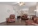 Spacious living room with hardwood floors, ceiling fan, and comfortable leather furniture at 15306 W Eureka Trl, Surprise, AZ 85374