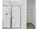 Modern shower with glass door and tiled wall next to shelving at 17815 W Denton Ave, Litchfield Park, AZ 85340
