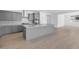 Modern kitchen features gray cabinets, stainless steel appliances, a large island, and stylish wood look tile floors at 17815 W Denton Ave, Litchfield Park, AZ 85340