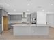 Modern kitchen features gray cabinets, stainless steel appliances, a large island, and a stylish backsplash at 17815 W Denton Ave, Litchfield Park, AZ 85340
