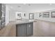 Open floor plan: Kitchen island with modern fixtures and eat-in bar overlooks the bright living space at 17815 W Denton Ave, Litchfield Park, AZ 85340