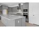 Modern kitchen features gray cabinets, stainless steel appliances, a large island, and a stylish backsplash at 17815 W Denton Ave, Litchfield Park, AZ 85340