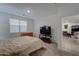 Spacious bedroom with a large bed and a view into the living room at 19945 W Badgett Ln, Litchfield Park, AZ 85340