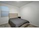 Small bedroom with a double bed and wooden nightstand at 19945 W Badgett Ln, Litchfield Park, AZ 85340