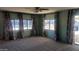 Spacious living room with light green walls, patterned curtains, and carpeted floor at 201 S Greenfield Rd # 16, Mesa, AZ 85206