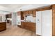 Kitchen with wood cabinets, white appliances, and view to the dining area at 21214 N 124Th Ave, Sun City West, AZ 85375
