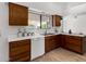 Kitchen features wood cabinets, white appliances, and corner sink at 21214 N 124Th Ave, Sun City West, AZ 85375