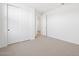 A carpeted bedroom with a closet and open door to the rest of the home at 22551 W Pontiac Dr, Surprise, AZ 85387