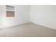 A carpeted bedroom with a window and a door at 22551 W Pontiac Dr, Surprise, AZ 85387