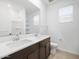 Bathroom featuring double sinks, large mirror, and tiled floors at 22563 W Pontiac Dr, Surprise, AZ 85387