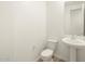 Half bathroom with pedestal sink, toilet, and mirror at 22563 W Pontiac Dr, Surprise, AZ 85387