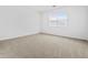 This bedroom features neutral carpet, white walls, and a window for natural light at 22563 W Pontiac Dr, Surprise, AZ 85387