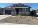 Inviting single-story home with a covered entry, a two-car garage, and xeriscaped front yard at 22563 W Pontiac Dr, Surprise, AZ 85387