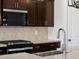 Close-up of a kitchen featuring a stainless steel faucet, gas cooktop, and patterned tile backsplash at 22563 W Pontiac Dr, Surprise, AZ 85387