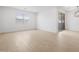 Bright living room with wood-look flooring, large windows, and a sliding glass door leading to the patio at 22563 W Pontiac Dr, Surprise, AZ 85387