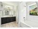 Clean bathroom with white tile, a bathtub, and dark vanity at 2444 E Garnet Ave, Mesa, AZ 85204