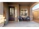 Front porch with two wicker chairs and a dark brown door at 2527 W Kit Carson Trl, Anthem, AZ 85086