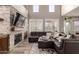 Living room with a stone fireplace and large TV at 2527 W Kit Carson Trl, Anthem, AZ 85086