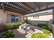 Relaxing patio area with seating and a pergola for shade at 27434 N 130Th Dr, Peoria, AZ 85383