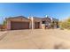 Three-car garage and front entry of house with desert landscaping at 3205 S Ponderosa Dr, Gold Canyon, AZ 85118